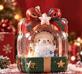 Front view of a light-up snowman gift box decoration with a red bow, clear rounded enclosure and green star-decorated base