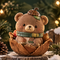 Front view of a brown woodland bear with an acorn-shaped hat, green scarf and layered leaf-shaped base