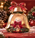 Front view of a gold-colored Christmas bell decoration with a cream bear inside, red bows and a green star-decorated base